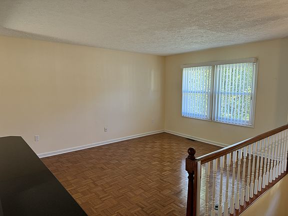 Family room across from open kitchen with hardwood floors.