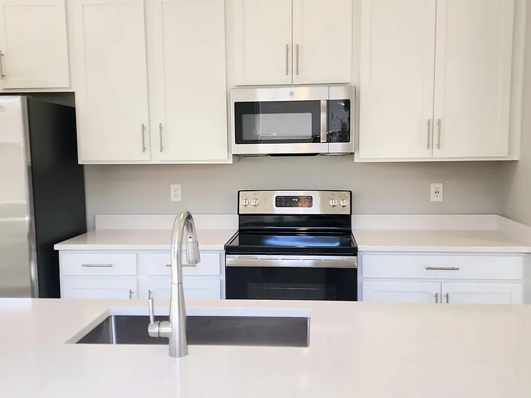 The spacious kitchen showcases pristine white 42-inch upper cabinets with ample storage