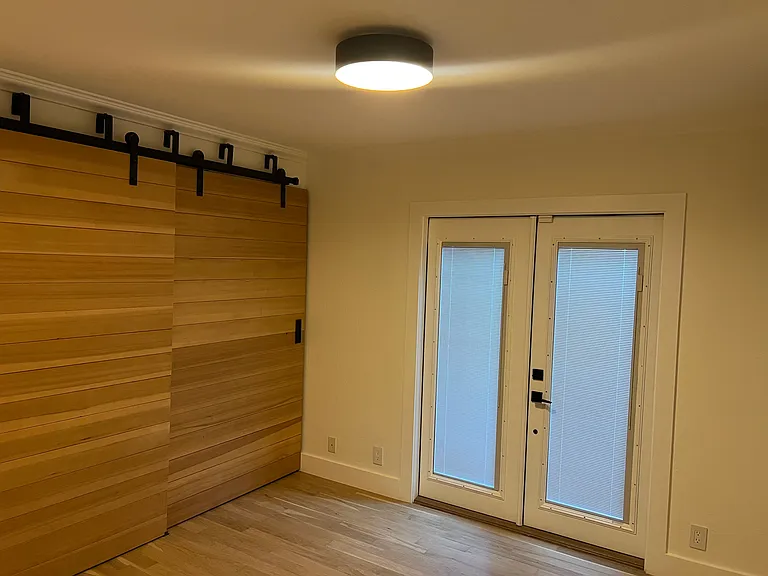 Bedroom #3 - Wooden barn doors. French doors to lower level garden.