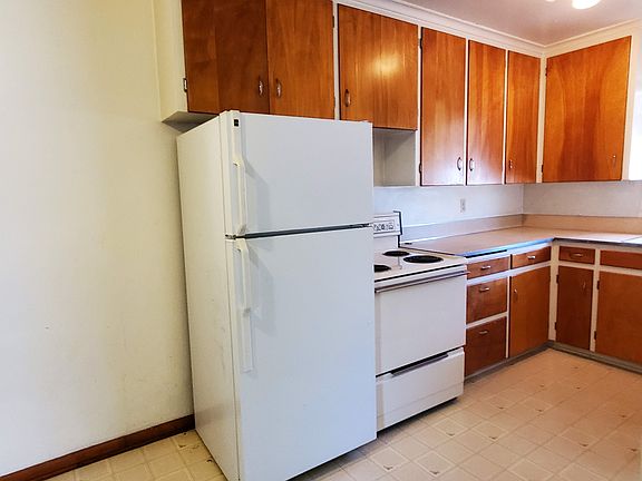 Kitchen has a refrigerator and an electric oven. Lots of cabinets, too.