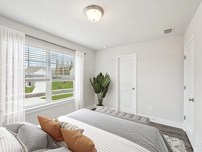 Elegant secondary suite with a queen bed and radiant natural light.