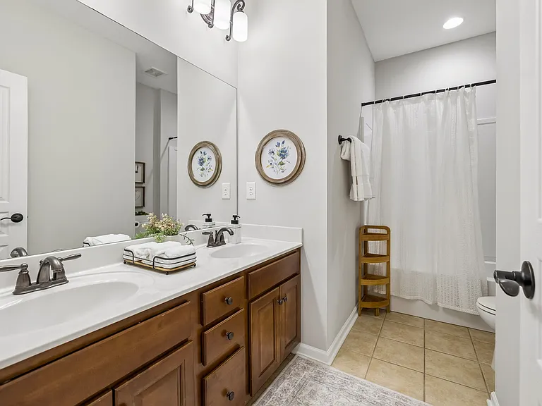 Conveniently serving the upstairs bedrooms, this well-appointed full bath features a spacious dual-sink vanity with abundant counter space and storage.