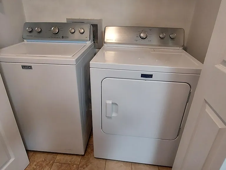 Maytag Washer & Dryer in utility space with folding doors.