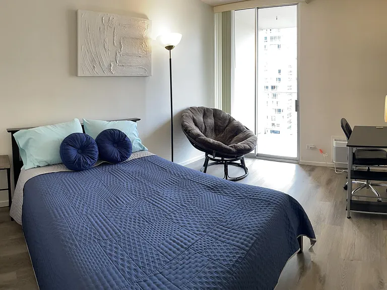 Master bedroom with slider to lanai, desk, AC unit. Linens included