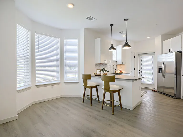 The kitchen peninsula with bar seating and a curved bay window nook make this kitchen the heart of the home. Garrett Harvest Junction West, Longmont, CO.