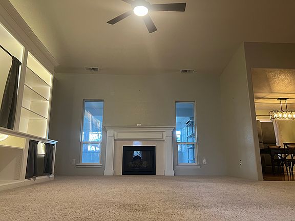 Gas fireplace and large entertainment center in the living room. The windows face out to the back room.