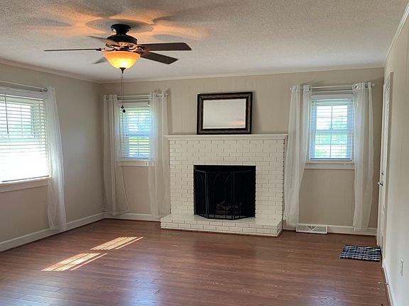 Living room and fireplace w/gas logs. Lots of natural light. Nutmeg cherry flooring throughout.