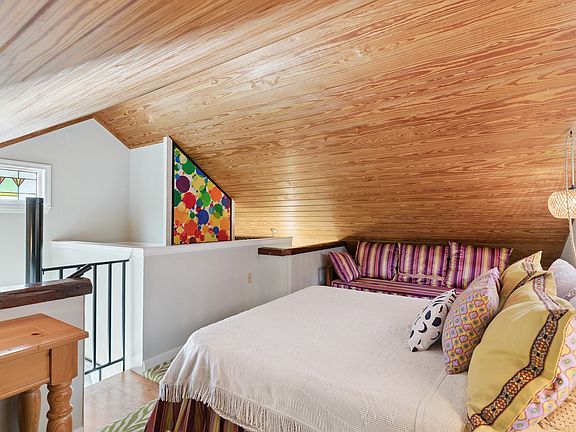 Alternate view of the upstairs loft showing the open stair access and sloped ceiling.