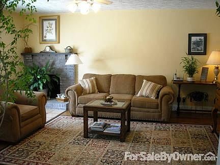 Sunny LR with fireplace, large picture window, and hardwood floors