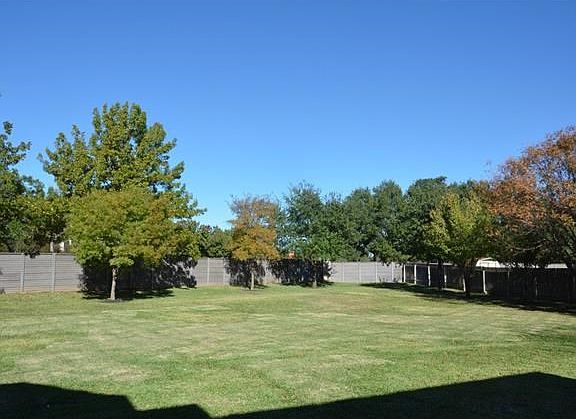 Huge private backyard with medium sized trees.