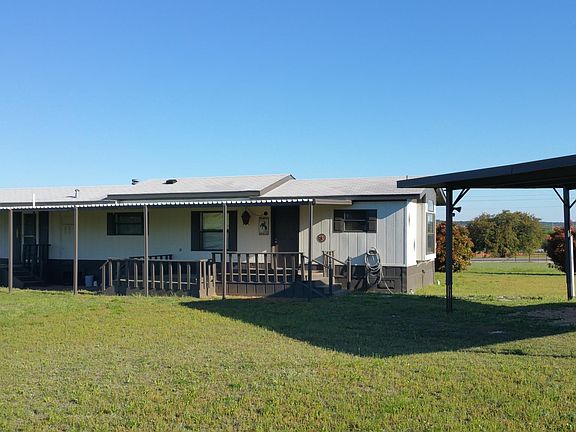 Front exterior with 3 decks and carport