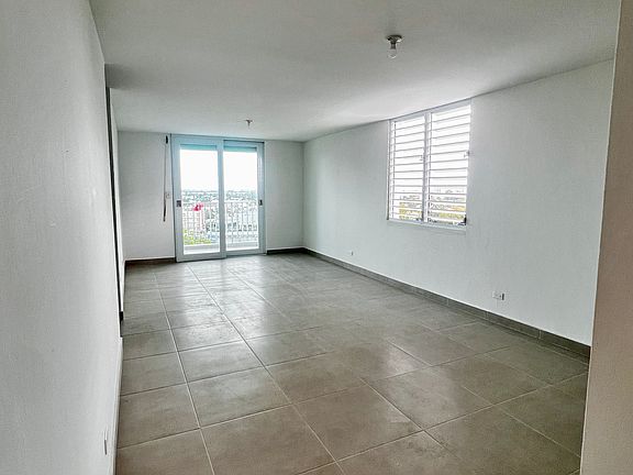 open living space with new windows and sliding door to the balcony