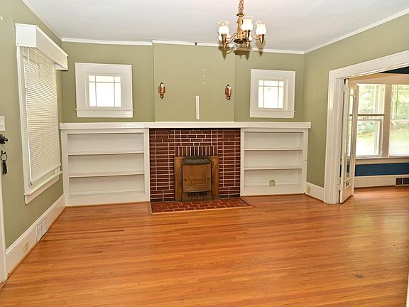 Living room with built in bookshelves and decorative fireplace.