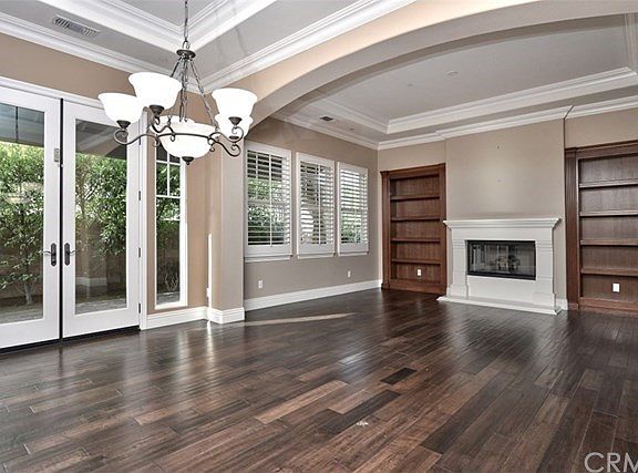 Formal living and dining room includes access to private side patio, plantation shutters, and warmin