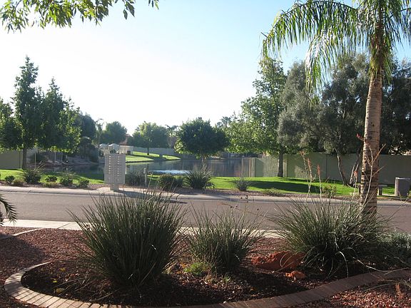 south facing front yard view of home looking out over green area & lake