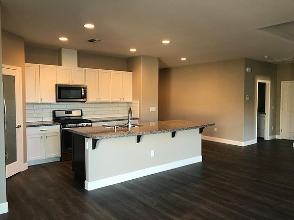 Gourmet kitchen with gas stove, pantry, microwave, and large breakfast bar