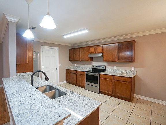 Kitchen with granite countertops, door to laundry room, pantry and garage