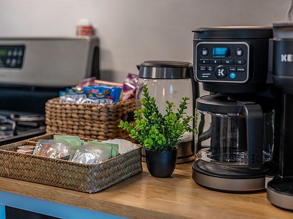 Key appliances include a stainless-steel oven, a full-sized fridge, and a convenient Keurig coffee maker.