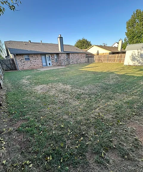 Spacious fenced backyard with large storage shed.