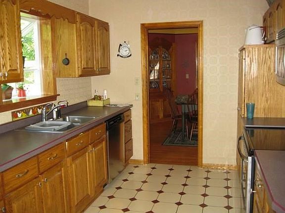Updated kitchen with custom raised panel cabinetry, stainless steel appliances, ceramic tile flooring and garden window over sink
