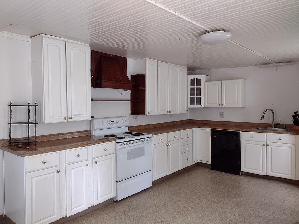 Full eat-in kitchen, with electric stove, fridge, and dishwasher. The front door to the outside patio and parking.