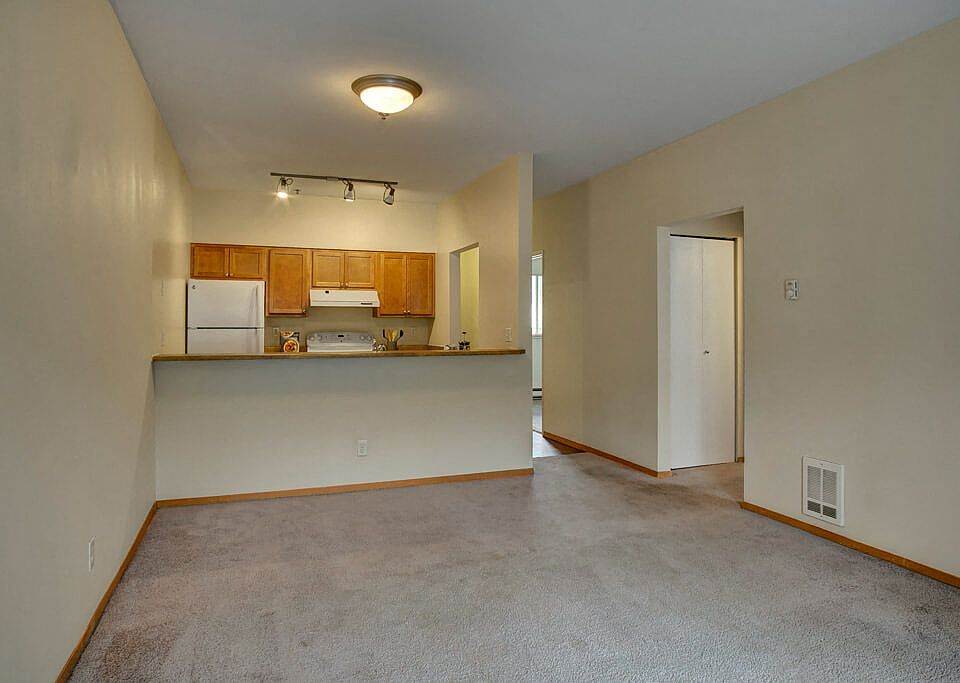 A large living room with a view into the kitchen over the bar