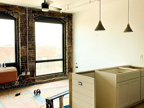 This studio with it's exposed brick, large windows with a view of Bent Paddle Brewery and fresh, modern ceiling fan and pendant light fixtures.