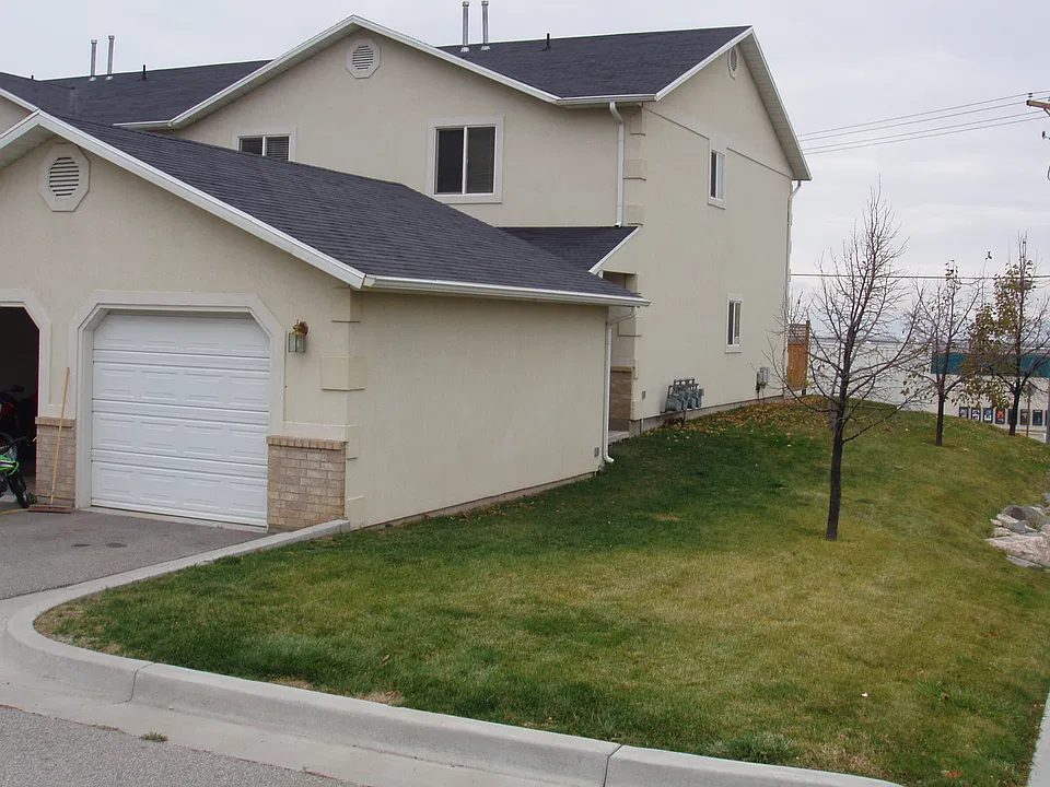 Front view with one car garage and yard