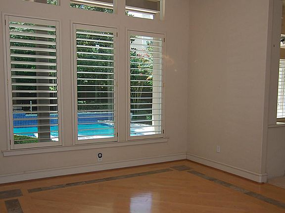 Formal dining room with solid oak floors enhanced with marble overlooking pool and gardens.