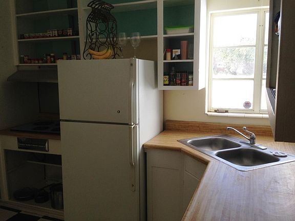 Kitchen with open shelf cupboards, fridge, built-in dishwasher, dble ss sink.
