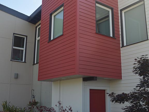 View through rolling gate showing patio area and front door