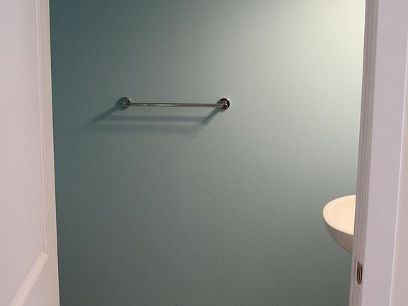Half bath with pedestal sink off the kitchen and living room.
