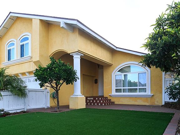 private fenced front yard with artificial turf and fruit tree