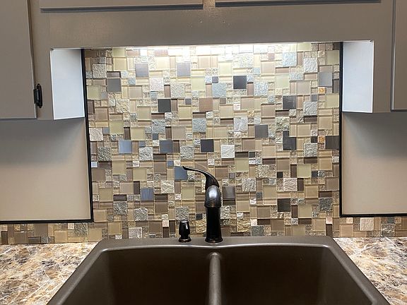 Stylish backsplash and double bowl stone kitchen sink with garbage disposal