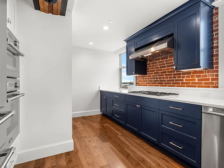 Amazing Kitchen with Designer Colored Cabinets; Thermador stove top and exposed brick in Kitchen. 3/4" hickory flooring through out