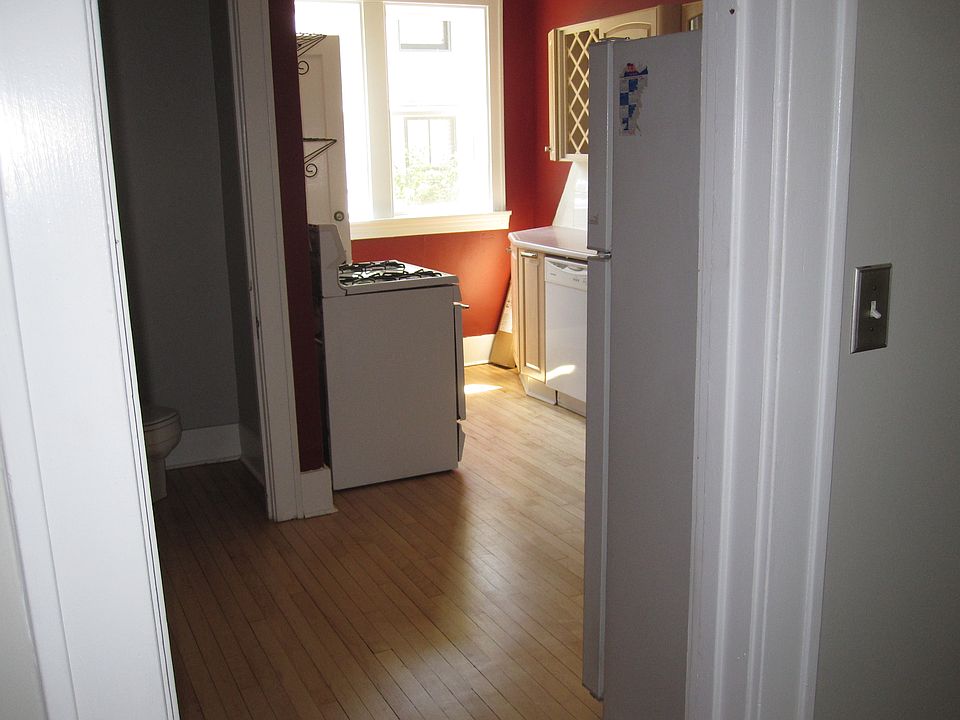 Picture of Kitchen from dinning room. The windows look out over the concrete patio. picture of newer stove and ref.