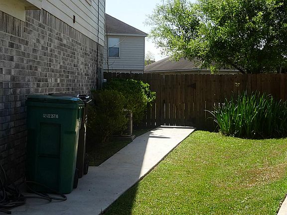 Well-kept side yard with trash area