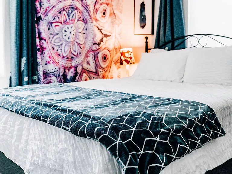 Bedroom #1 on main level. Queen bed, bedside table, small dresser, closet, lamps, blackout curtains, comfy linens.
