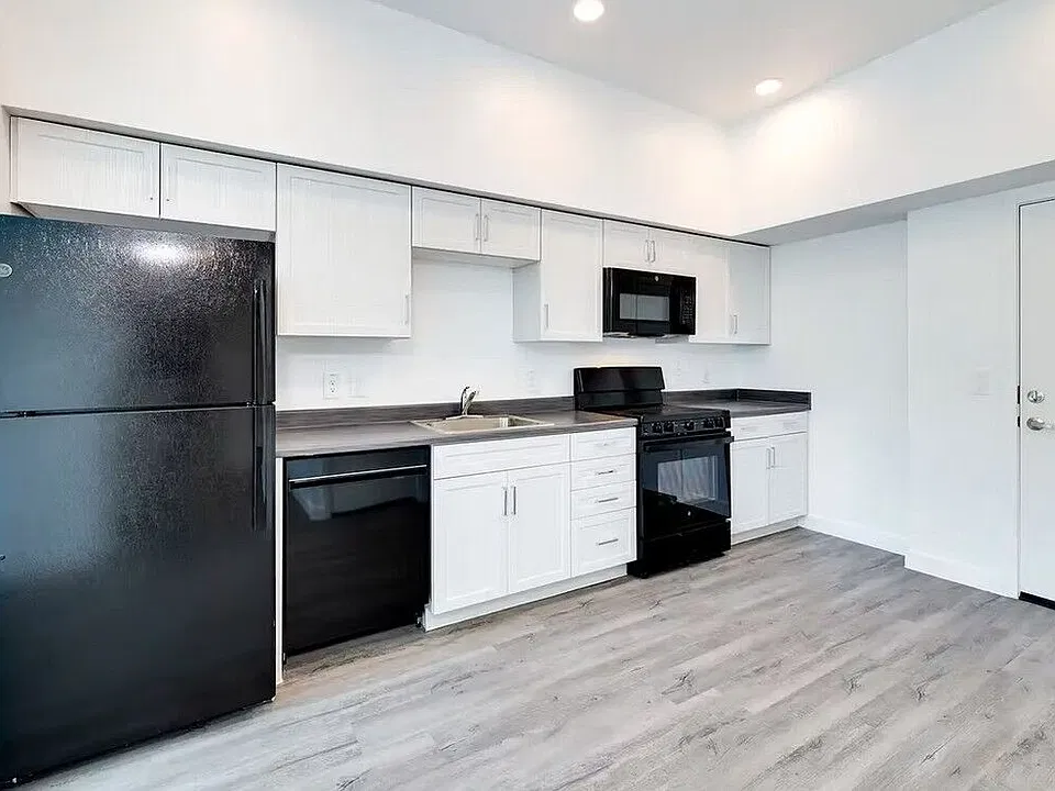 Kitchen with black appliances and white cabinets