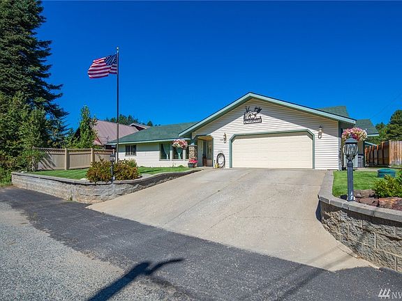 Easy maintenance front yard with terraced stone wall, 2 car garage and side yard fencing for privacy.