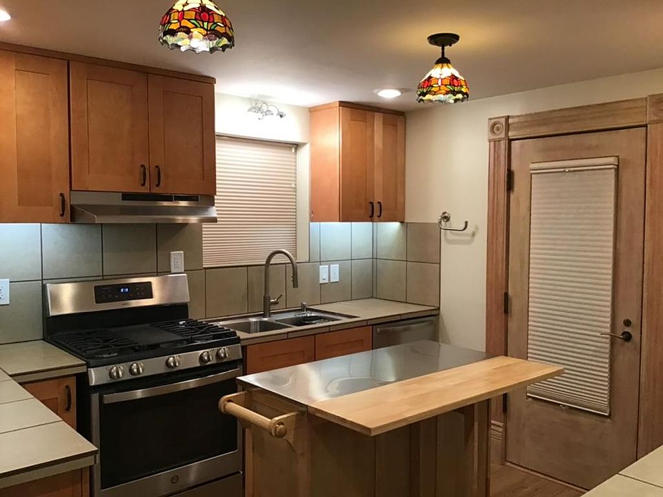 Spacious, well-lit kitchen with lots of cabinet space, and portable drop-leaf cart for versatility and extra storage.