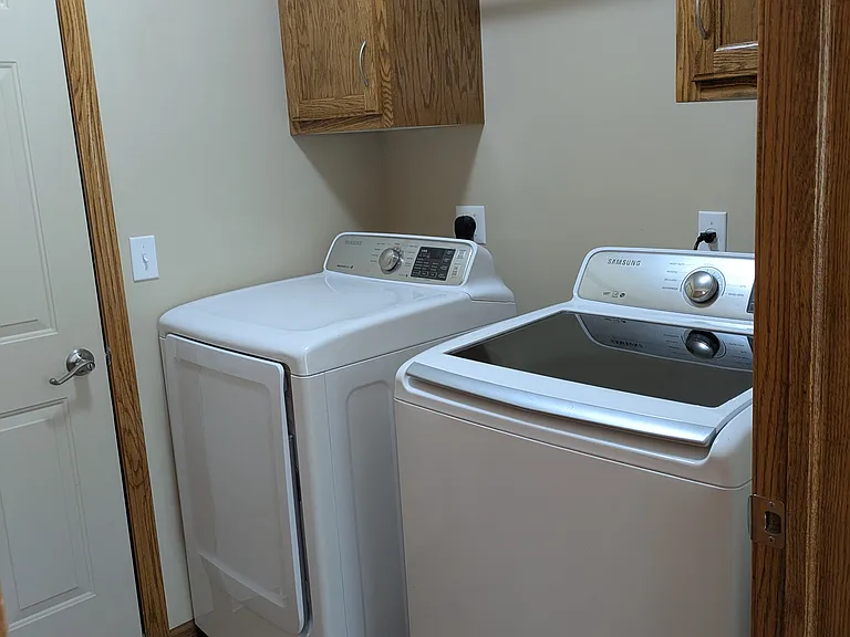 Laundry with storage and hanging area. Washer and dryer included.