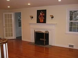 Living Room with Oak Floors, Recessed Lighting and Woodburning Fireplace