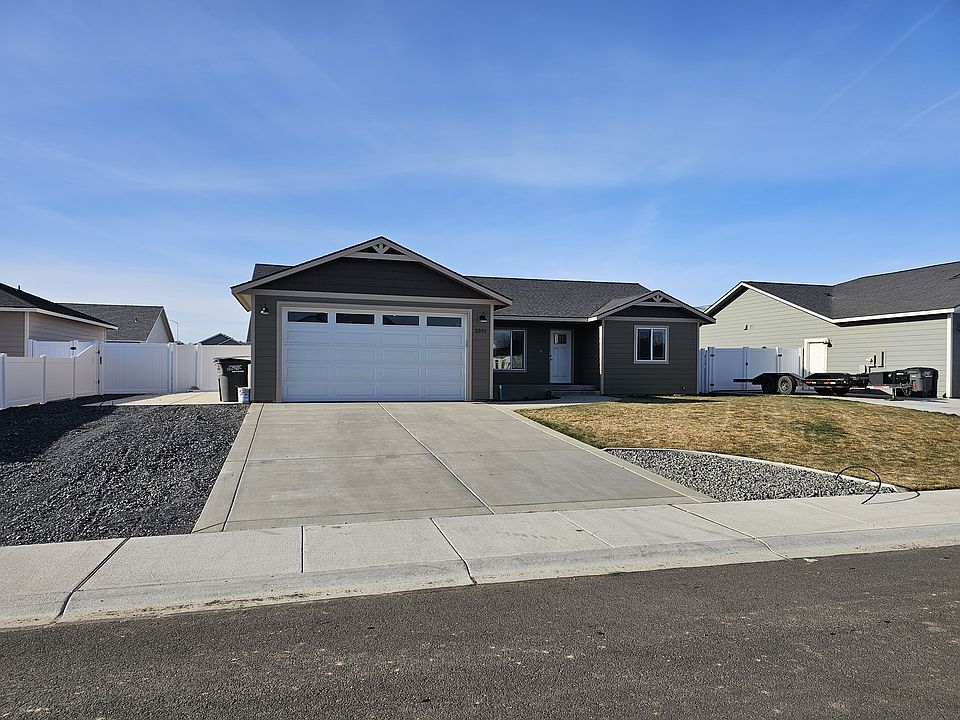 Home looking at front door. Large concrete slab on left side of garage for toy storage and/or parking. There is an electrical, water, & sewer hookup for a RV