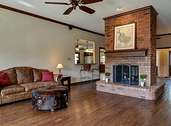 Spacious Great Room features 2-Sided Brick Fireplace w Gas Starter and Custom Ceiling Fan!