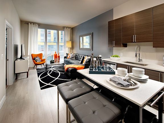 Living area and open concept kitchen with granite countertops and European-style cabinetry, stainless-steel appliances, movable kitchen island and hard surface flooring