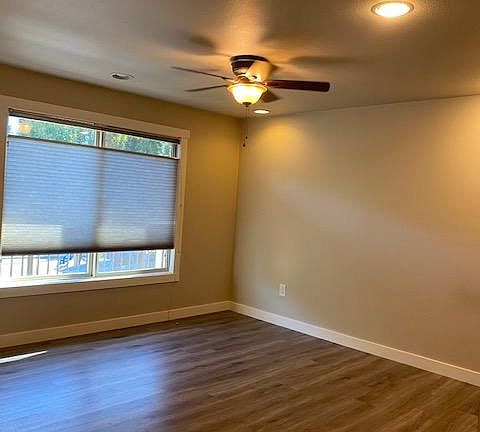 Living room features up/down shades for privacy and light, recessed lighting and ceiling fan with light