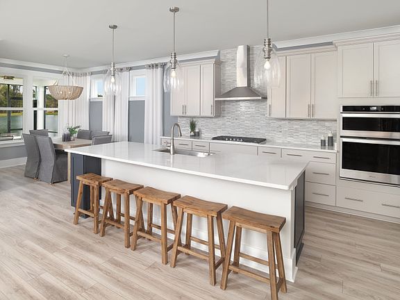 Gourmet Kitchen with decorative lighting with white cabinets and large pantry