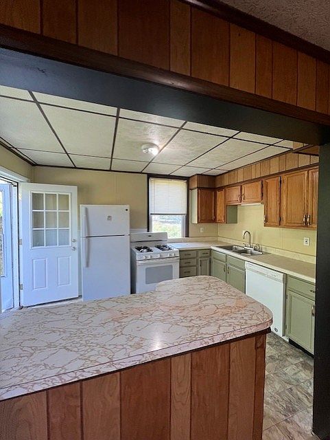 Kitchen view from dining room. Gas range, refrigerator, and dishwasher.