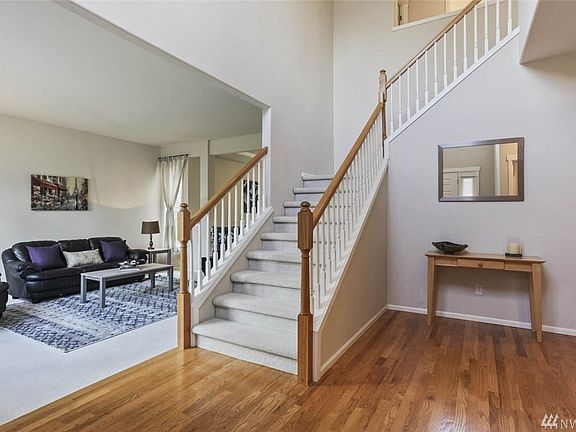 Enter to soaring vaulted ceilings and hardwood floors that sweep through to the dining room and kitchen.